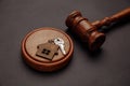 Judge gavel and key chain in shape of two splitted part of house on wooden background. Concept of real estate auction or Royalty Free Stock Photo