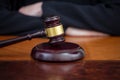 Judge gavel on law court desk, blur female crossed hands, close up view