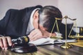 Judge gavel with lawyers, Gavel on wooden table and Counselor or Male lawyer is tired and migraine headaches during hard working Royalty Free Stock Photo