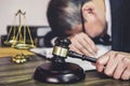 Judge gavel with lawyers, Gavel on wooden table and Counselor or Male lawyer is tired and migraine headaches during hard working Royalty Free Stock Photo