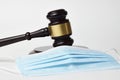 Judge gavel and medical protective mask on a white background