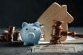 Judge gavel, piggy bank and wooden model of house. Concept of real estate auction or dividing house when divorce Royalty Free Stock Photo