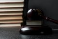 Judge gavel beside pile of books on wooden background Royalty Free Stock Photo