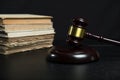 Judge gavel beside pile of books on wooden background Royalty Free Stock Photo