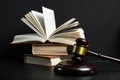 Judge gavel beside pile of books on wooden background Royalty Free Stock Photo