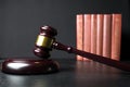 Judge gavel beside pile of books on wooden background Royalty Free Stock Photo