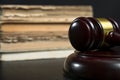 Judge gavel beside pile of books on wooden background Royalty Free Stock Photo