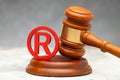 Judge gavel and red trademark sign gray