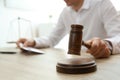 Judge with gavel at table in courtroom, closeup. Royalty Free Stock Photo