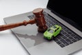 Judge gavel and toy car on laptop computer keyboard. Symbol of law, justice and online car auction. Royalty Free Stock Photo