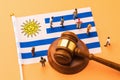 Judge gavel, Uruguay flag and plastic toys on colored background, Uruguay litigation concept Royalty Free Stock Photo