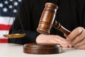 Judge with gavel at white wooden table near flag of United States, closeup Royalty Free Stock Photo