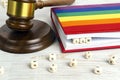 Judge gavel with word Law in wooden blocks in red notebook and rainbow LGBT flag on wooden table Royalty Free Stock Photo