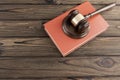 A judge hammer, a book on a wooden background. Royalty Free Stock Photo