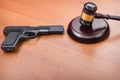 Judge hammer, pistol on the background of wooden table. Concept is not legally carrying weapons. concept of the court and the righ Royalty Free Stock Photo