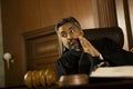 Judge With Hands Clasped Looking Away In Court Room Royalty Free Stock Photo