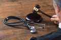 Judge Hitting Gavel With Stethoscope In Courtroom