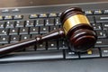 A judge presides over a court, brandishing the mace of justice while a laptop and keyboard display evidence in an ongoing