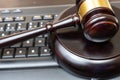 A judge presides over a court, brandishing the mace of justice while a laptop and keyboard display evidence in an ongoing