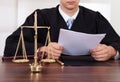 Judge reading document at table in courtroom Royalty Free Stock Photo