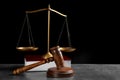 Judge`s gavel, book and scales on grey table against black background. Criminal law concept Royalty Free Stock Photo