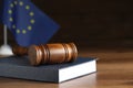 Judge`s gavel and book on wooden table against European Union flag. Space for text Royalty Free Stock Photo