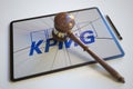 Broken tablet computer screen with logo of KPMG and judge's gavel. Editorial conceptual 3d rendering