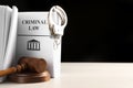 Judge`s gavel, Criminal Law book and handcuffs on table against black background. Space for text