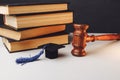 Judge's gavel and graduation cap with books on the table Royalty Free Stock Photo