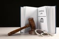 Judge`s gavel, handcuffs and Criminal law book on table against black background