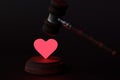 The judge`s gavel hits the glowing heart. Divorce concept. 3D render