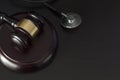 Judge`s gavel and medical stethoscope on black wooden table with copy space Royalty Free Stock Photo