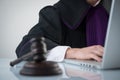 Judge`s gavel. Modern white desk with an open laptop. White background. Royalty Free Stock Photo