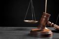 Judge`s gavel and scales on grey table against black background. Criminal law concept Royalty Free Stock Photo