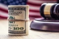Judge`s hammer gavel. Justice dollars banknotes and usa flag in the background. Court gavel and rolled banknotes. Royalty Free Stock Photo