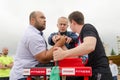 The judge sets the wrestlers` hands correctly before the start of the bout. Arm wrestling competitions