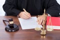 Judge signing contract paper at desk