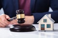 Judge Striking Gavel Near House Model Royalty Free Stock Photo