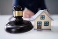 Judge Striking Gavel Near House Model Royalty Free Stock Photo