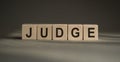 Judge - word from wooden blocks with letters, Judge, try, referee, adjudicate concept, black leather background Royalty Free Stock Photo