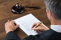 Judge Writing On Paper In Courtroom Royalty Free Stock Photo