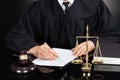 Judge writing on paper at desk Royalty Free Stock Photo
