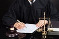 Judge writing on paper at desk Royalty Free Stock Photo