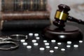 Judge& x27;s gavel with handcuffs, drugs on wooden table