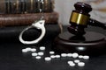 Judge& x27;s gavel with handcuffs, drugs on wooden table