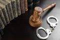 Judges Gavel, Handcuffs And Old Book On The Black Table