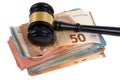 Judges gavel resting on wad of euro banknotes close-up on white background