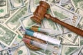 Judges Gavel And Syringe With Injection On Dollar Cash Backgroun