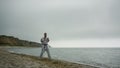 Judo fighter doing workout on sandy beach. Man training combat technique.