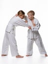 In a judo lesson, a boy and a girl fight and capture Royalty Free Stock Photo